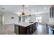 Bright kitchen with stainless steel appliances, island with sink, and modern pendant lighting at 118 Green Branch Blvd, Groveland, FL 34736