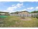 Wide shot of the backyard with firepit and covered patio, fenced in for privacy at 12370 Se 100Th Ct, Belleview, FL 34420