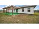 Backyard of home featuring a pergola-covered patio with vibrant green artificial turf at 12370 Se 100Th Ct, Belleview, FL 34420