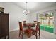 Cozy dining area with a wooden table, chandelier, and sliding glass doors leading to the backyard at 12370 Se 100Th Ct, Belleview, FL 34420