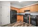 Well-lit kitchen with wood cabinets, modern appliances, stylish backsplash, and durable flooring at 12370 Se 100Th Ct, Belleview, FL 34420