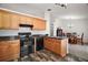 Functional kitchen with wooden cabinetry, modern appliances, and a view towards the dining room at 12370 Se 100Th Ct, Belleview, FL 34420