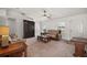 Spacious living room with neutral carpet, large windows, and a ceiling fan, perfect for relaxation at 12370 Se 100Th Ct, Belleview, FL 34420