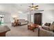 Bright living room featuring neutral carpet, a ceiling fan, and classic wood furniture at 12370 Se 100Th Ct, Belleview, FL 34420