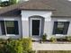 Close-up of the front entrance highlighting the black front door, clean lines, and manicured landscaping at 12807 Sugar Ct, Grand Island, FL 32735