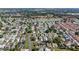 High-angle view of an established community with sidewalks, manicured lawns, a lake, and tree-lined streets at 1310 Leone Ln, The Villages, FL 32159