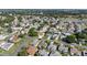 Scenic aerial view of a charming neighborhood with lush green spaces, sidewalks, and mature trees at 1310 Leone Ln, The Villages, FL 32159