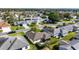 Low altitude aerial view of a suburban house with a screened in lanai and trimmed landscaping at 1310 Leone Ln, The Villages, FL 32159