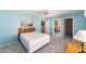 Light blue bedroom with view to attached bath and walk-in closet at 1310 Leone Ln, The Villages, FL 32159