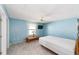 Light blue bedroom featuring a ceiling fan and neutral carpet at 1310 Leone Ln, The Villages, FL 32159