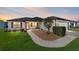 Charming single-story home featuring a well-manicured lawn, a stone walkway, and an attached garage at 1310 Leone Ln, The Villages, FL 32159