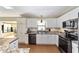 Close up view of kitchen with stainless appliances, white cabinets, and tile backsplash at 1310 Leone Ln, The Villages, FL 32159