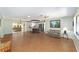 Spacious living room with wood flooring, a cozy couch, and an open view into the kitchen at 1310 Leone Ln, The Villages, FL 32159