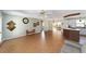 Open living space with wood-look floors, a ceiling fan, and a view into the kitchen and Florida room at 1310 Leone Ln, The Villages, FL 32159