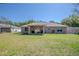 Exterior view of the home showcasing the backyard and patio area with a well maintained lawn at 13662 Se 55Th Ave, Summerfield, FL 34491