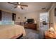 Spacious bedroom with ceiling fan, TV, and wood-look flooring, creating a comfortable and modern space at 13662 Se 55Th Ave, Summerfield, FL 34491