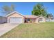Charming single-story home with a well-manicured lawn, attached garage and an American flag at 13662 Se 55Th Ave, Summerfield, FL 34491