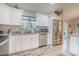 Bright kitchen featuring white cabinets, stainless steel appliances, and granite countertops at 13662 Se 55Th Ave, Summerfield, FL 34491