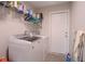 Bright laundry room includes a modern washer, dryer, wire shelving, and neutral paint at 13662 Se 55Th Ave, Summerfield, FL 34491