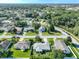 Aerial view displays a neighborhood with lush green lawns, mature trees and multiple well-maintained homes at 1407 Island Cove Dr, Deland, FL 32724