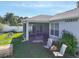 Backyard with patio, chairs, landscaping, and white vinyl perimeter fencing at 1407 Island Cove Dr, Deland, FL 32724