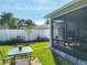 Landscaped backyard with a screened patio, table with seating, and white vinyl fence at 1407 Island Cove Dr, Deland, FL 32724