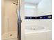 This bathroom showcases a tub and shower with decorative border at 1407 Island Cove Dr, Deland, FL 32724