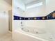 This bathroom showcases a tub and shower with decorative border at 1407 Island Cove Dr, Deland, FL 32724