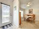 Cozy dining area with a ceiling fan, wood table, and chairs is located just beyond the decorative front door at 1407 Island Cove Dr, Deland, FL 32724