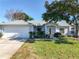 Charming single-story home with a well-maintained lawn and mature trees on a sunny day at 1407 Island Cove Dr, Deland, FL 32724
