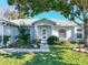 The home's entrance showcases a decorative glass front door, mature landscaping, and a well-kept lawn at 1407 Island Cove Dr, Deland, FL 32724