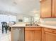Spacious kitchen with a stainless steel dishwasher, light wood cabinets, and a view into the dining area at 1407 Island Cove Dr, Deland, FL 32724