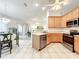 Bright, tiled kitchen with stainless steel appliances, light wood cabinets and open access to a dining area at 1407 Island Cove Dr, Deland, FL 32724