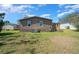 A view of the backyard showing the back of the house, lawn, and utilities at 1541 Doral Cir, Lady Lake, FL 32159