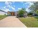 Charming home featuring a carport, well-manicured lawn, and tropical landscaping creating great curb appeal at 1541 Doral Cir, Lady Lake, FL 32159
