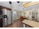 The kitchen flows into the dining area, stainless steel refrigerator, and access to the backyard at 1541 Doral Cir, Lady Lake, FL 32159