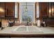 Traditional kitchen sink featuring tile backsplash, updated faucet and hardware, and double basin sink at 1541 Doral Cir, Lady Lake, FL 32159