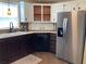 Well-appointed kitchen featuring stainless steel refrigerator and ample cabinet space at 1541 Doral Cir, Lady Lake, FL 32159