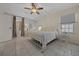 Bright main bedroom features an en-suite bathroom, ceiling fan, and neutral decor at 1541 Doral Cir, Lady Lake, FL 32159