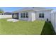Spacious backyard with lush green grass, a screened-in patio, and ample space for outdoor activities at 1589 Armstrong Ave, The Villages, FL 32163