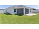 Spacious backyard with lush green grass, a screened-in patio, and ample space for outdoor activities at 1589 Armstrong Ave, The Villages, FL 32163