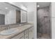 Bathroom featuring a double vanity, a large mirror, and a walk-in shower at 1589 Armstrong Ave, The Villages, FL 32163