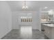 Bright dining room with tiled floors, modern chandelier and archway leading to sunroom, with kitchen in the background at 1589 Armstrong Ave, The Villages, FL 32163