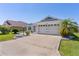 Charming home featuring a well-manicured lawn, beautiful landscaping, and an attached two car garage at 1589 Armstrong Ave, The Villages, FL 32163
