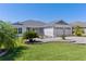 Charming home featuring a well-manicured lawn, beautiful landscaping, and an attached two car garage at 1589 Armstrong Ave, The Villages, FL 32163