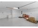 Spacious garage offering ample storage with a refrigerator, doors, and boxes at 1589 Armstrong Ave, The Villages, FL 32163