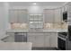 Well-lit kitchen featuring stainless steel appliances, light gray cabinets, and a complementary backsplash at 1589 Armstrong Ave, The Villages, FL 32163