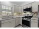 Updated kitchen featuring stainless steel appliances, shaker cabinets and mosaic tile backsplash at 1589 Armstrong Ave, The Villages, FL 32163