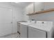 Clean laundry room features a washer, dryer, sink, and storage cabinets above units at 1589 Armstrong Ave, The Villages, FL 32163
