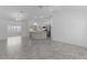 Bright open-concept living space with kitchen island, dining area, modern tile floors and neutral paint scheme at 1589 Armstrong Ave, The Villages, FL 32163
